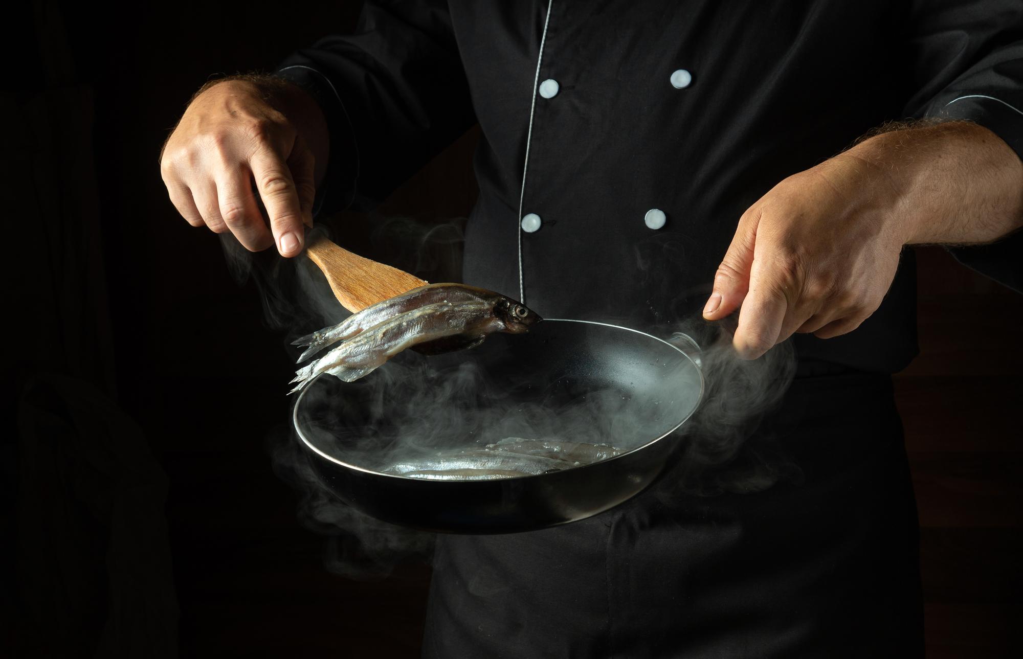 Szef kuchni przygotowujący delikatne danie w eleganckiej kuchni